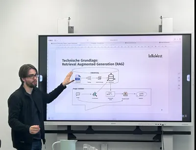 Eine Person erklärt mit erhobener Hand vor einem Whiteboard eine Grafik zur technische Funktion eines RAG KI Chat Bots.