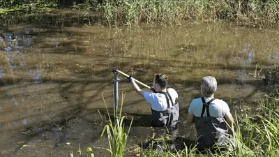 Die Metallstange für den Sensor im Löschwasserteich in Ziesar wird installiert